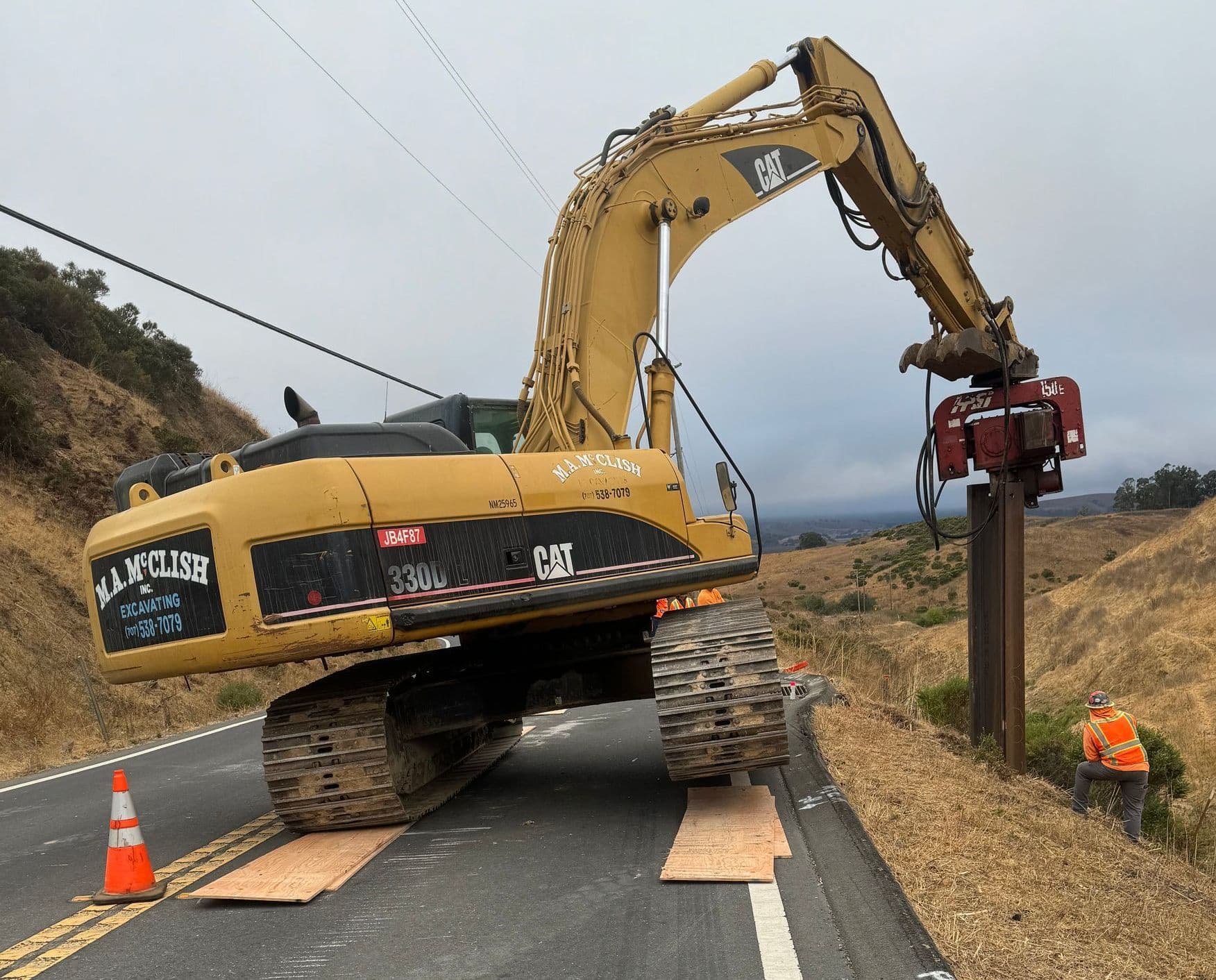 Excavator on hillside washout repair